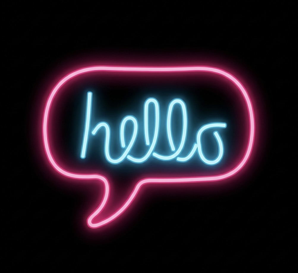 A glowing neon sign on a black background, featuring a bright pink chat bubble outline with the word "hello" written inside in light blue cursive neon tubing.